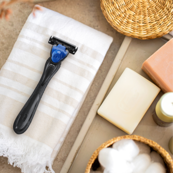 Golarka męska BIC Hybrid 3 Flex, czarno-niebieska, z 3 ostrzami, na ręczniku, w otoczeniu mydeł. Z góry.