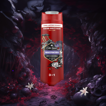 Czerwona butelka Old Spice Night Panther 3-in-1 żelu pod prysznic i szamponu z czarno-złotą etykietą, na tle jaskini.
