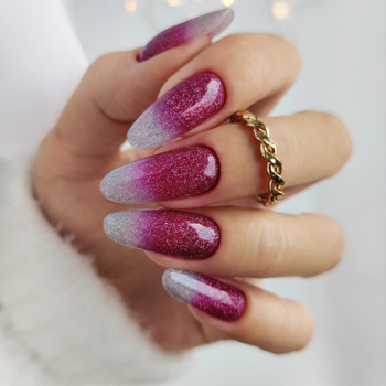 Lakier z efektem Flash: długie, błyszczące paznokcie ombre różowo-srebrne, widok dłoni z pierścionkiem.