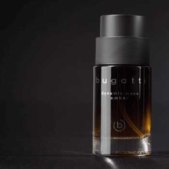 Bugatti Dynamic Move Amber, męskie perfumy w bursztynowej butelce z czarną nakrętką, ujęcie z przodu na ciemnym tle.