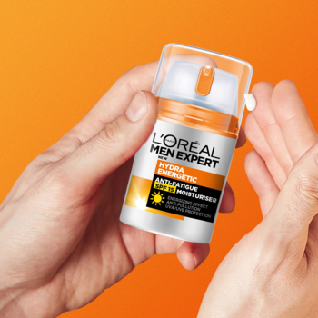 Męski krem nawilżający L'Oreal Men Expert Hydra Energetic SPF15, pomarańczowa butelka w dłoniach.
