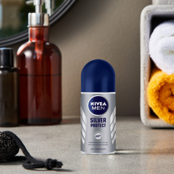 NIVEA MEN Silver Protect roll-on, srebrna butelka z niebieską nakrętką, na tle łazienkowego blatu.