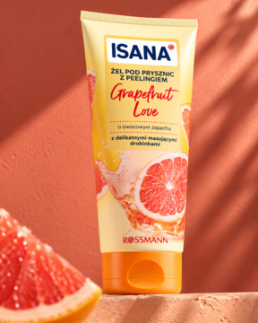 Żel pod prysznic Isana Grapefruit Love z peelingiem w żółtej tubce na pomarańczowym tle, z plasterkiem grejpfruta.