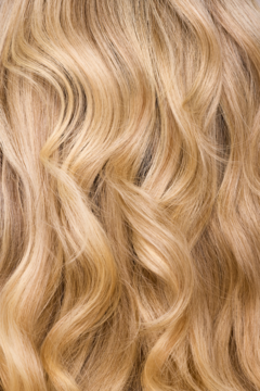 Lśniące, faliste blond włosy, rozjaśnione szamponem z naturalnym kompleksem, muśnięte słońcem.