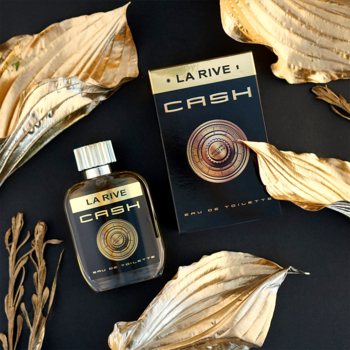 Złota butelka i pudełko perfum La Rive Cash EDT, leżące na czarnym tle z ozdobnymi złotymi liśćmi.