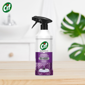 Cif Perfect Finish spray antybakteryjny, biała butelka z fioletową etykietą, na drewnianym blacie łazienki.