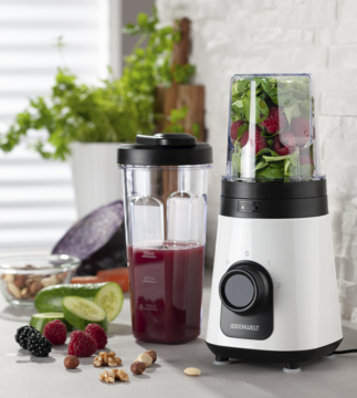 Biały blender do smoothie z bidonami 600/300 ml, zieleń i buraki w kielichu. Obok świeże owoce, orzechy.