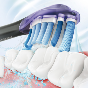 Philips Sonicare Premium Gum Care: fioletowo-czarna główka szczoteczki czyści zęby, widoczna woda i piana.