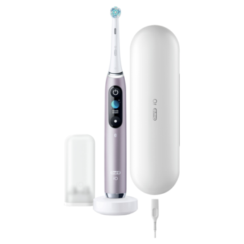 Oral-B iO fioletowa szczoteczka elektryczna z wyświetlaczem, na białej ładowarce, obok etui podróżne i kabel.