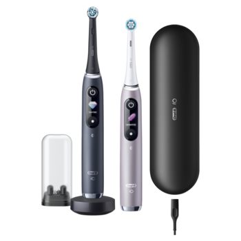 Dwie elektryczne szczoteczki Oral-B iO (szara i fioletowa) z ładowarką, etui podróżnym. Widok z przodu.