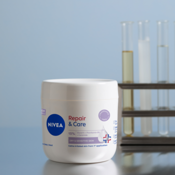 NIVEA Repair & Care Sensitive krem regenerujący w białym słoiku, z przodu, w tle probówki laboratoryjne.