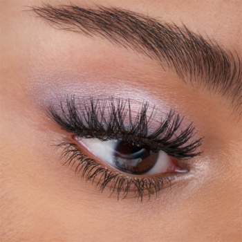 Zbliżenie na oko z długimi, podkręconymi sztucznymi rzęsami Catrice Dramatic Curl Lashes, różowo-fioletowy cień.