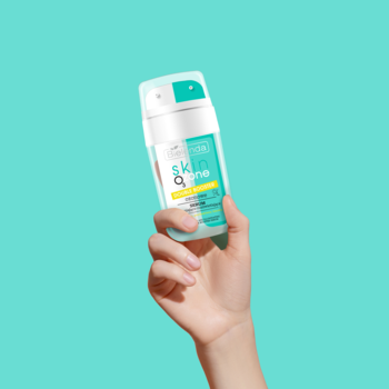 Bielenda Skin O3zone Double Booster, podwójne serum dotleniające, w biało-turkusowej butelce trzymanej w dłoni na gładkim tle.