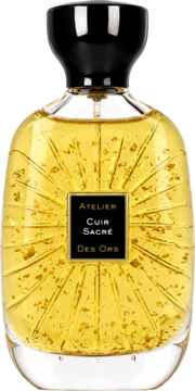 Złoty flakon perfum Cuir Sacre Atelier des Ors, z płatkami złota i rzeźbionym słońcem, czarny korek, widok z przodu.