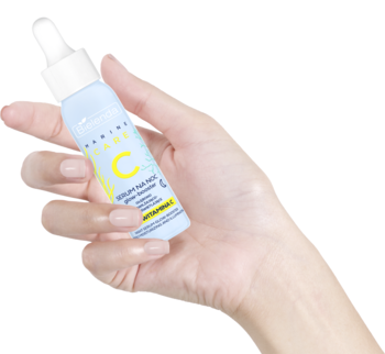 Ręka trzyma jasnoniebieskie serum Bielenda Marine Care C z 12% witaminy C na noc, butelka z pipetą.
