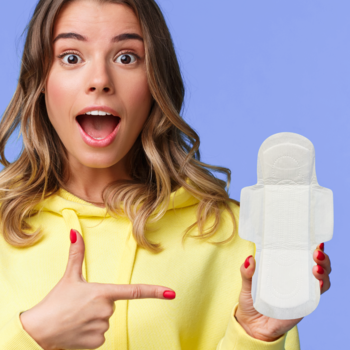 Podpaska JONI TEENS z bawełny organicznej, biała, miękka, na dzień, trzymana przez uśmiechniętą kobietę.