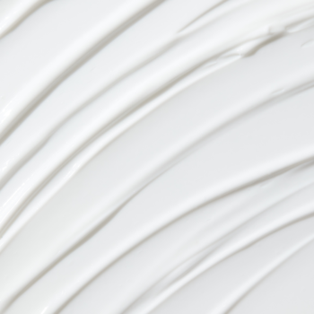 Krem nawilżający z ceramidami o gęstej, białej teksturze, widok z góry. Widoczne pofalowane smugi.