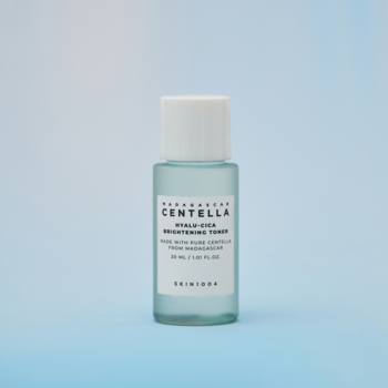 Tonik SKIN1004 Centella Hyalu-Cica Brightening w błękitnej butelce 30ml z białą zakrętką, na niebieskim tle.