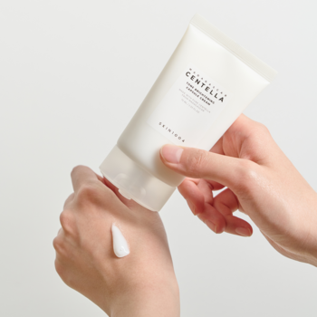 Biała tubka kremu Skin1004 Madagascar Centella Tone Brightening Cream wyciskana na dłoń, ukazując białą teksturę.