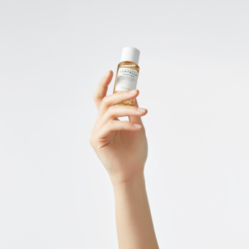 Skin 1004 Madagascar Centella Toning Toner w małej butelce z jasnym płynem, trzymanej w uniesionej dłoni.