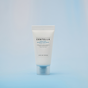 Biała tubka Skin1004 Centella Hyalu-Cica Water-Fit Sun Serum SPF50+ travel size, na jasnoniebieskim tle.
