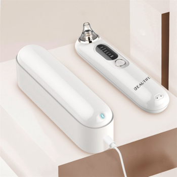 Białe urządzenie do mikrodermabrazji B-Derma Glow PRO z przezroczystą głowicą i stacją ładującą, widok z góry.
