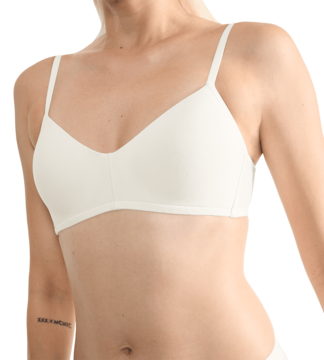 Sloggi Go Casual: biała bawełniana braletka na kobiecie. Miękkie, lekko wycięte miseczki, cienkie ramiączka.