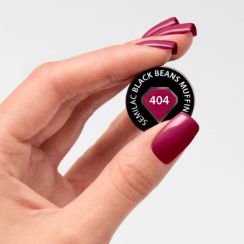 Semilac 404 Black Beans Muffin. Dłoń z burgundowymi paznokciami trzyma czarny wzornik tego trwałego lakieru.