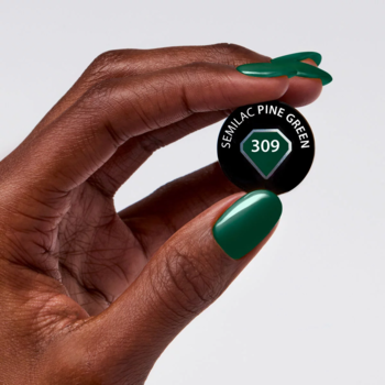 Dłoń o ciemnej karnacji trzyma czarny wzornik Semilac 309 Pine Green. Paznokcie błyszczą głęboką zielenią.