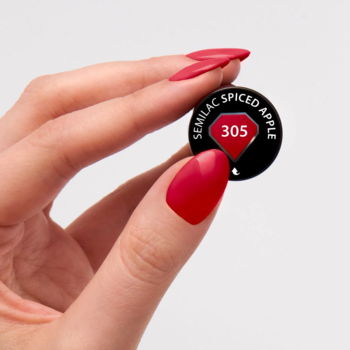 Dłoń z czerwonymi paznokciami trzyma próbnik koloru Semilac Spiced Apple 305, czerwonego lakieru hybrydowego.