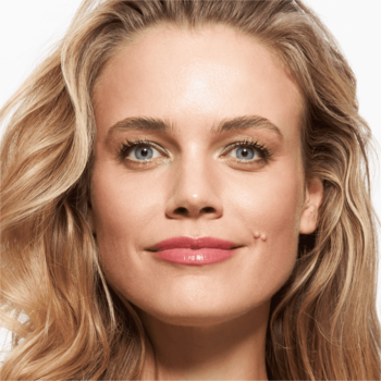 Zbliżenie na uśmiechniętą blondynkę z niebieskimi oczami, naturalnie podkreślonymi brwiami żelem Super Glue 020 Light Brown.