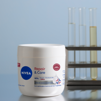 NIVEA Repair & Care krem z mocznikiem i gliceryną w białym słoiku, widok z przodu, z probówkami w tle.