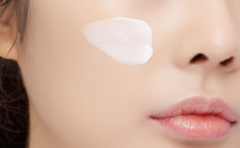 Aplikacja Pure Block SPF 45 PA+++ kremu przeciwsłonecznego na policzku; lekki, niebielący krem na dzień.