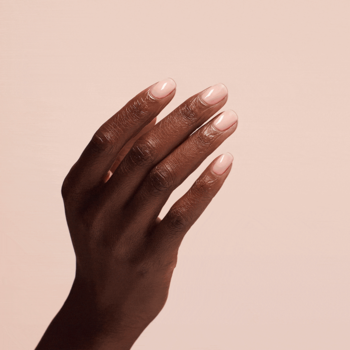 OPI Nail Envy Bubble Bath: Manicurowana dłoń z wzmocnionymi, delikatnie różowymi paznokciami na brzoskwiniowym tle.