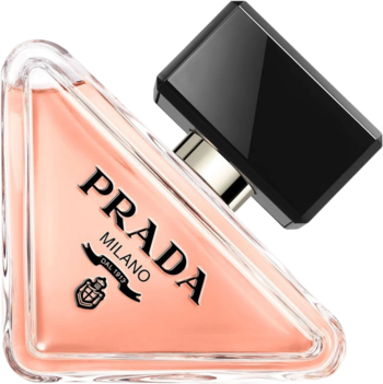 Perfumy damskie Prada Paradoxe, butelka w kształcie trójkąta z brzoskwiniowym płynem i czarną nakrętką, widok z góry pod kątem.