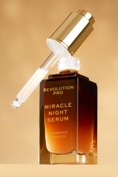 Revolution PRO Miracle Night Serum w ciemnej szklanej butelce z otwartym złotym aplikatorem na beżowym tle.