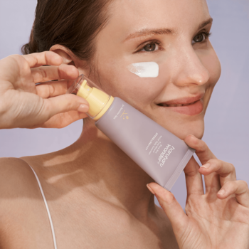 Kobieta aplikuje mineralny krem do twarzy SPF 50+ Haruharu Wonder Black Rice z fioletowej tubki.