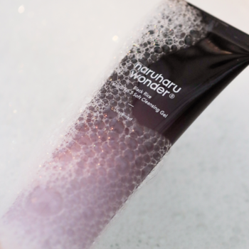 Haruharu Wonder Black Rice Cleansing Gel, transparentna tubka z gradientem fioletu i czerni, z bąbelkami.