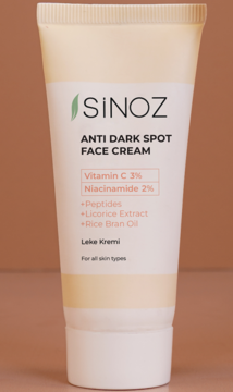 Sinoz Anti Dark Spot Face Cream, beżowa tubka z 3% wit. C i 2% niacynamidem, widok z przodu na brązowym tle.