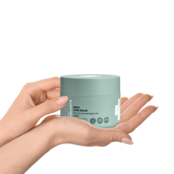 Miętowy balsam lipidowy DermaKnowlogy MD01 w okrągłym słoiczku, trzymany w dłoniach na białym tle.