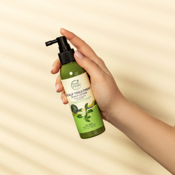 Dłoń trzyma zieloną wcierkę Petal Fresh z aplikatorem. Do skóry głowy, wzmacnia i zagęszcza włosy.