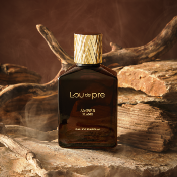 Męska woda perfumowana Lou De Pre Amber Flame. Brązowa butelka z fakturowaną złotą zakrętką, na drewnie.