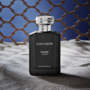Lou De Pre Dark Cedrus męska woda perfumowana, czarna butelka z srebrnym korkiem, widok frontalny, na piasku i siatce.