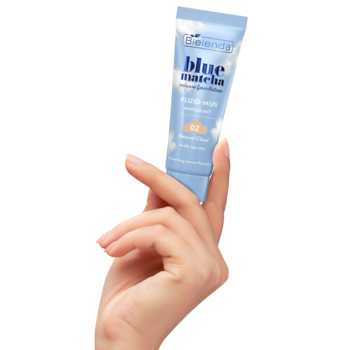 Dłoń trzyma małą, jasnoniebieską tubkę podkładu Bielenda Blue Matcha 02 Natural Cloud. Lekkie krycie.