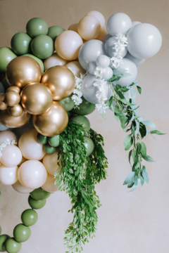 Złote balony Glossy PartyDeco 30 cm w lateksowej girlandzie z zielonymi i beżowymi elementami, widok z bliska.