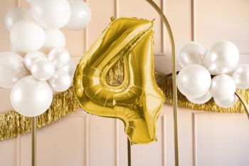 Duży złoty balon foliowy cyfra 4, satynowy, w otoczeniu białych balonów i złotej girlandy, na urodziny.