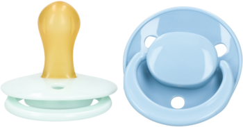 Dwa smoczki Babydream 3-24m: zielony lateksowy z profilu, niebieski okrągły z otworem wentylacyjnym, widok z przodu.