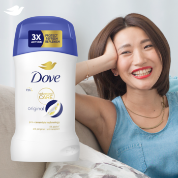 Antyperspirant Dove Advanced Care Original 72h w białym sztyfcie z niebieską nakrętką, obok uśmiechniętej kobiety.