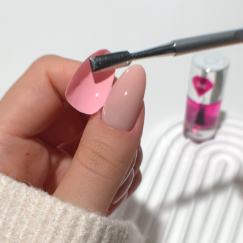 Semilac Jelly Nail Tape, baza peel-off. Dłoń z paznokciami nude i różowym, aplikator, produkt w tle.