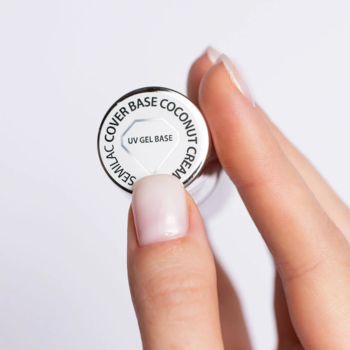 Dłoń z naturalnym mani trzyma białe wieczko Semilac Cover Base Coconut Cream UV Gel Base.